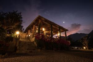 ein beleuchtetes Gebäude mit Treppen und Blumen in der Nacht in der Unterkunft La Confianza Hotel in Lunahuaná