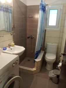 a bathroom with a sink and a toilet and a window at STUDIO WITH TENIS COURT AND MINI BASKET in Aigio
