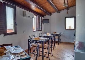 un comedor con mesas, sillas y ventanas en Cefalu in Blu, en Cefalú