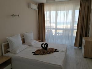 a hotel room with a bed with a towel on it at Apart Allure Dobi in Primorsko +89 photos