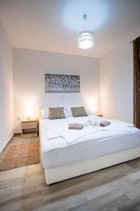 een witte slaapkamer met een groot wit bed. bij Villa Guliva in Rab
