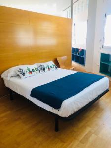1 dormitorio con 1 cama grande y cabecero de madera en Estudio acogedor renfe, en Alicante