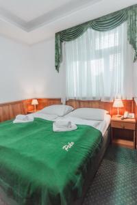 - une chambre avec une couverture verte sur un lit dans l'établissement Hotel Peko, à Prague