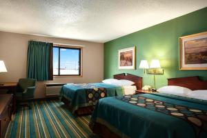 una camera d'albergo con due letti e una finestra di Coratel Inn & Suites by Jasper New Richmond a New Richmond