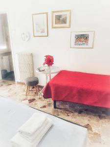 マテーラにあるççç Matera Short Term Rooms çççのリビングルーム(赤いベッド1台、テーブル付)