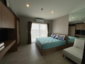 a bedroom with a bed and a couch and a window at Luxury La casita Huahin in Hua Hin