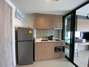 a small kitchen with a refrigerator and a sink at Luxury La casita Huahin in Hua Hin