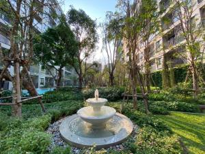 a fountain in a park with trees and buildings at Luxury La casita Huahin in Hua Hin