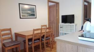 eine Küche mit einem Tisch und Stühlen sowie einem TV in der Unterkunft To Tutaj in Szklarska Poręba