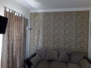 een woonkamer met een bank en een bakstenen muur bij Vodice Mladen apartman za familiju in Vodice