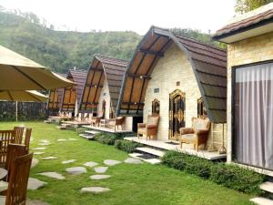 a row of cottages with chairs and tables at Zelobi Omnivora Cottage in Kintamani