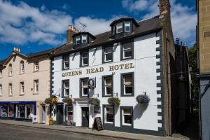 a white building on the side of a street at Queenshead Hotel Kelso in Kelso