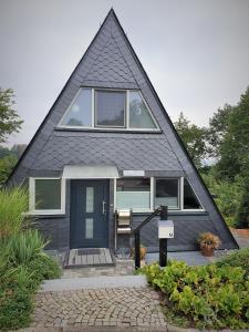 uma casa preta com um telhado de gambrel em Bigge Huus Ferienhaus em Olpe