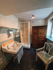 a bathroom with a sink and a shower and a chair at Leithen Lodge in Innerleithen