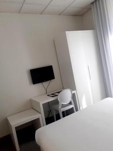a bedroom with a desk with a computer and a tv at Hôtel P.L.M. in Cannes