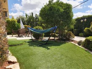 a hammock in the grass in a garden at Zimmer Monte in Dāliyat el Karmil