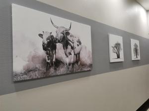 a painting of two cows hanging on a wall at 84 On Marshall in Johannesburg