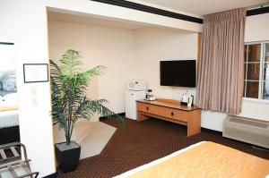 a hotel room with a desk and a tv at Americas Best Value Inn & Suites; Atlantic Inn & Suites in Atlantic