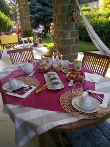 a table with a purple table cloth with food on it at B&B Serra Pineta in Serramazzoni