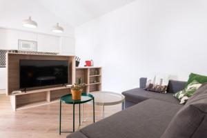 een woonkamer met een bank en een tv bij Apartamento moderno en Costa Calma in Costa Calma