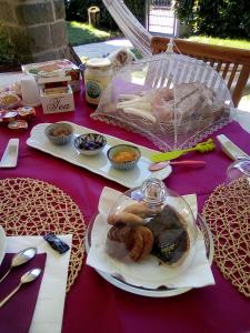 B&B Serra Pineta في Serramazzoni: طاولة أرجوانية مع طبق من الطعام عليها