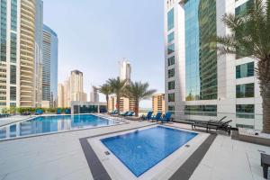 ein Schwimmbad in der Mitte einer Stadt mit Gebäuden in der Unterkunft Spacious 1BR Botanica Towers, Dubai Marina in Dubai