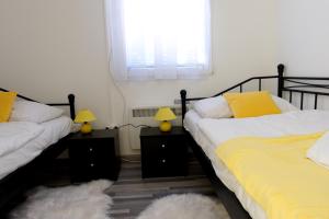 2 camas en una habitación con 2 lámparas y una ventana en Gabriella Panzió, en Bük