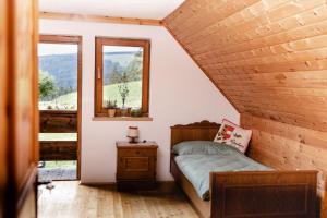 a small bedroom with a bed and two windows at Moosbacher-Hütte in Aichberg