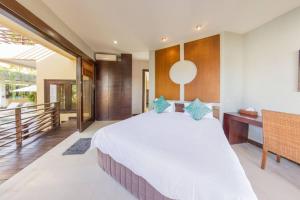 een slaapkamer met een groot bed en een bureau bij Villa Simone Bali in Ungasan
