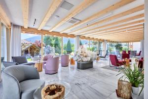 a lobby with chairs and tables and windows at Mineralienhotel Natznerhof in Naz-Sciaves