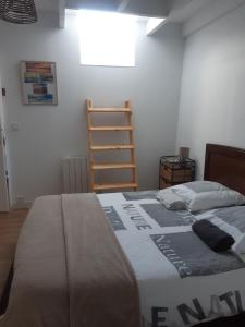 Un dormitorio con una cama con una escalera. en Les Greniers De Blanche, en Le Vivier-sur-Mer