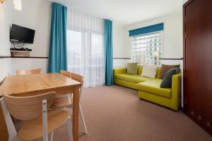 salon ze stołem i żółtą kanapą w obiekcie Villa Baltic -Apartament nr 9 w Chałupach