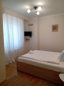 ein kleines Schlafzimmer mit einem Bett und einem TV in der Unterkunft Valentina Bg Apartment in Sofia