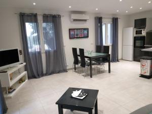Elsanais في فيغاري: غرفة معيشة مع طاولة وكراسي وتلفزيون