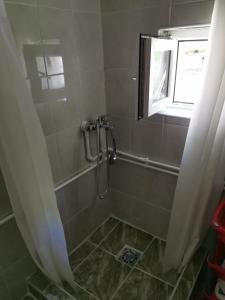 a shower in a bathroom with a window at Konak Mileva in Sjenica