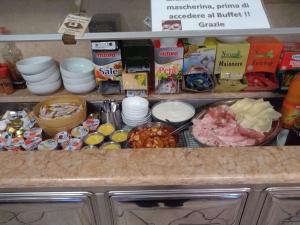 a counter top with many different types of food at Hotel Sport in Coredo
