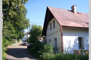 ein weißes Haus mit einem roten Dach und einer Auffahrt in der Unterkunft Pobyt v CHKO České středohoří pod horou Milešovkou in Teplice