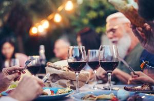 un grupo de personas sentadas en una mesa con copas de vino en Gasthof OHR, en Eisenstadt