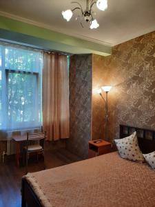 a bedroom with a bed and a desk and a window at Guest House on 174А Shevchenko Street in Anapa