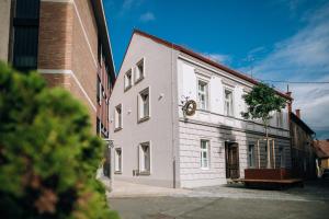 un edificio blanco con un reloj a un lado en Becycle Sustainable stay and travel en Maribor