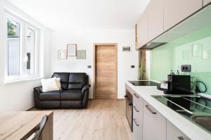 a kitchen with a black leather couch in a room at CAPRARIA appartments in historic center, with private parking in Koper