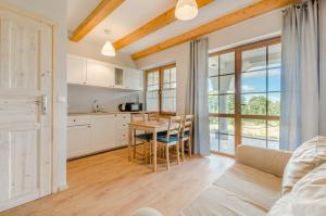a kitchen and living room with a table and chairs at Pensjonat Rybical in Ryn