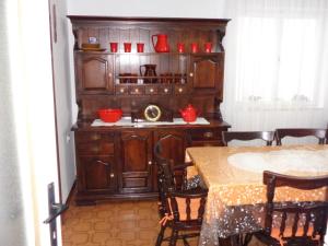 a kitchen with wooden cabinets and a table with chairs at APARTMAN ZORAN MARUSIC in Marusici 