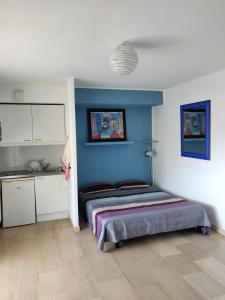 ニースにあるAppartement Terrasse Niceの青い壁のベッドルーム1室(ベッド1台付)