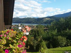 a view of a lake from a house with flowers at Apartments Krista in Seeboden