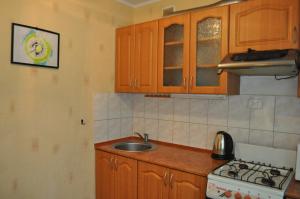 een keuken met houten kasten, een wastafel en een fornuis bij Apartment for rent Reasonable price in Krementsjoek
