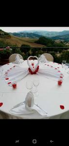 una mesa blanca con copas de vino encima en Agriturismo Le Francesche en Nocera Umbra