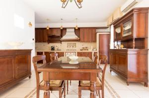 a kitchen with wooden cabinets and a wooden table and chairs at La Maison in Grottaglie +18 photos