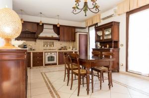 a kitchen with a wooden table and chairs at La Maison in Grottaglie