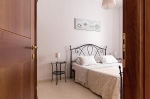 a bedroom with a bed with white sheets and a table at La Maison in Grottaglie